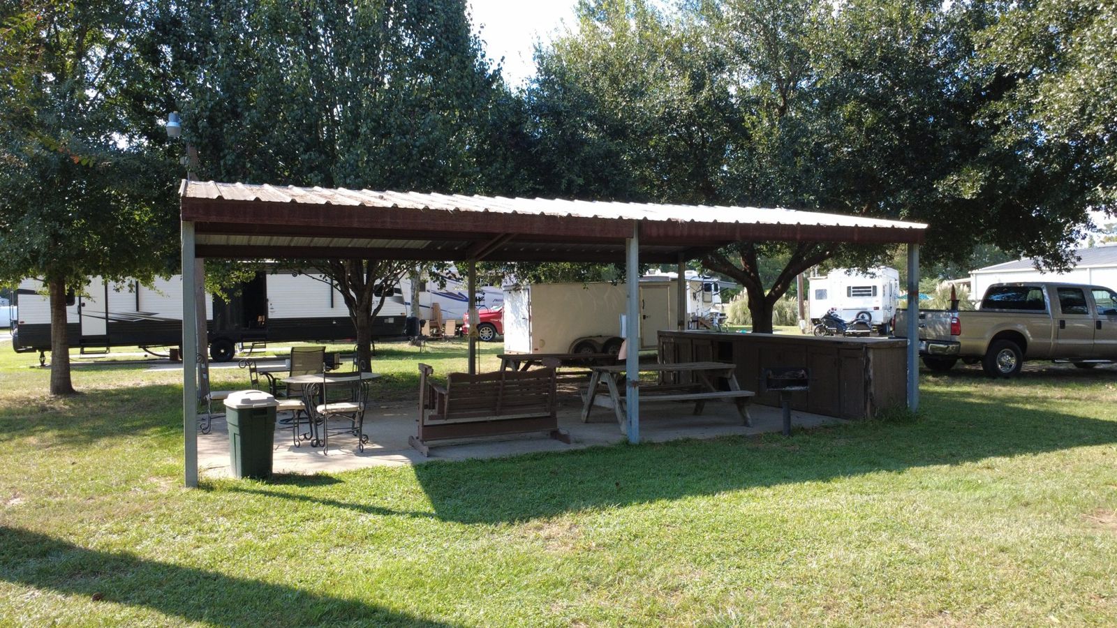 Covered picnic pavilion with tables and grills at Red Cloud RV Park
